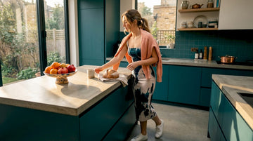 Woman in patterned midi dress in kitchen
