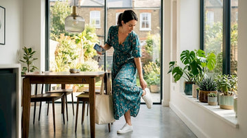 Woman putting on shoes in entryway in maxi dress