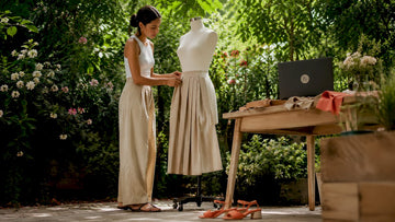 Woman styling a beige midi skirt on mannequin