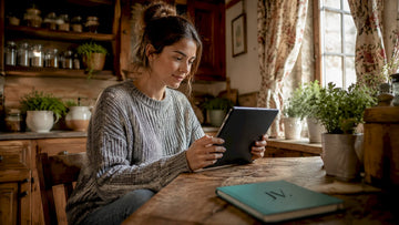Woman browsing fashion deals on tablet at home
