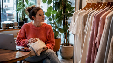 Woman choosing affordable wardrobe essentials in bedroom