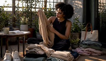 Woman evaluating clothing quality at home
