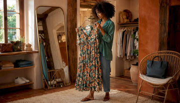 Woman examining sustainable dress in home dressing room