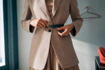 Woman styling blazer over dress with belt