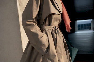 Editorial close-up of trench coat styling details