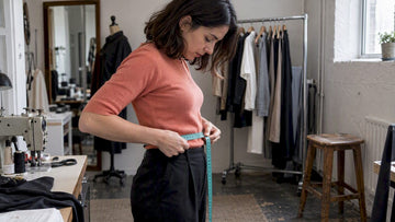 Woman measuring waist for clothing size